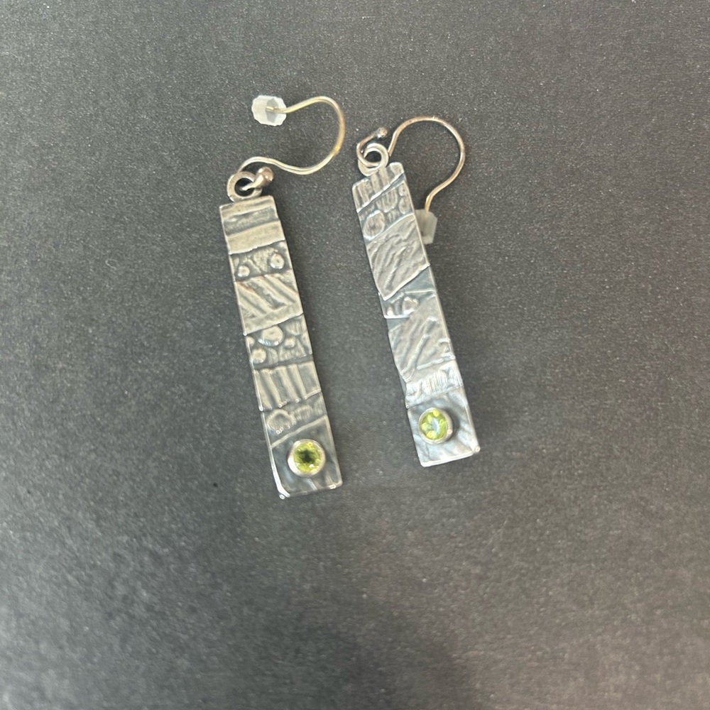 Silver earrings with green jewel.